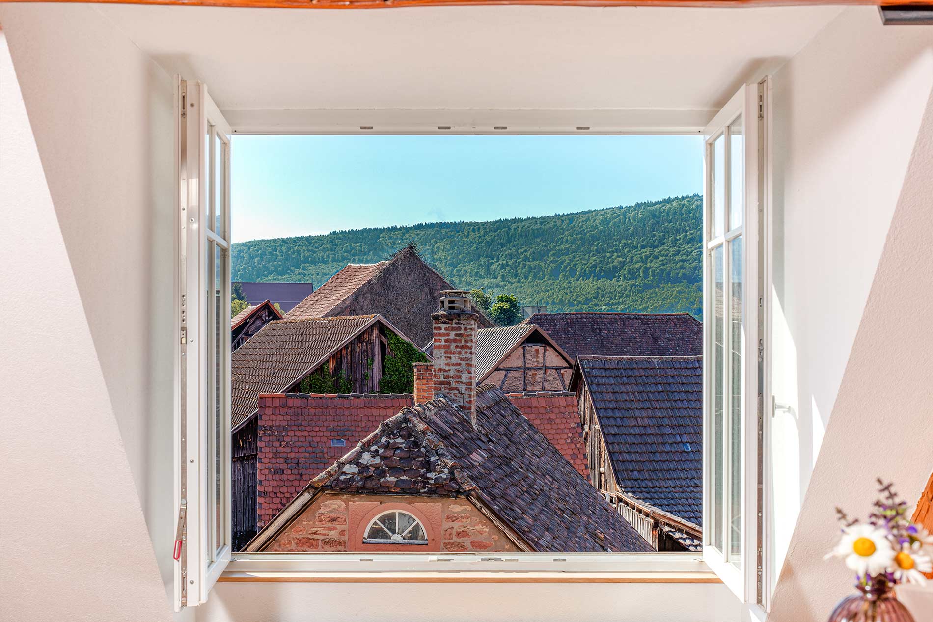 Offenes Fenster mit Blick über Dächer